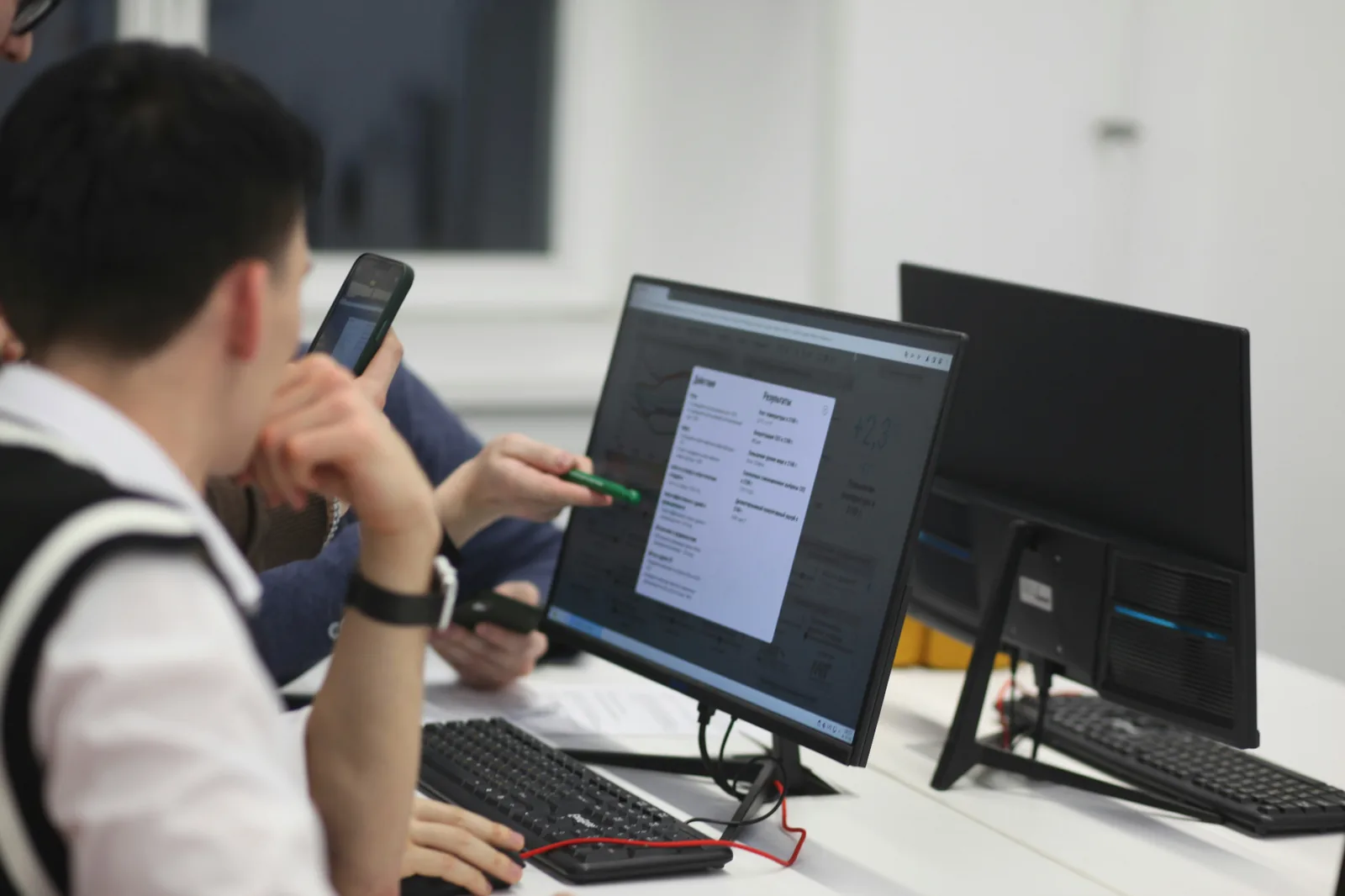 People reviewing work together at desktop computers